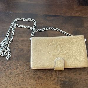Chanel beige caviar long bifold wallet with front snap closure.